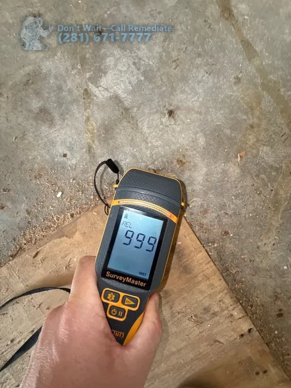 Moisture meter reading 999, the top of its scale, on the subfloor under the hardwood