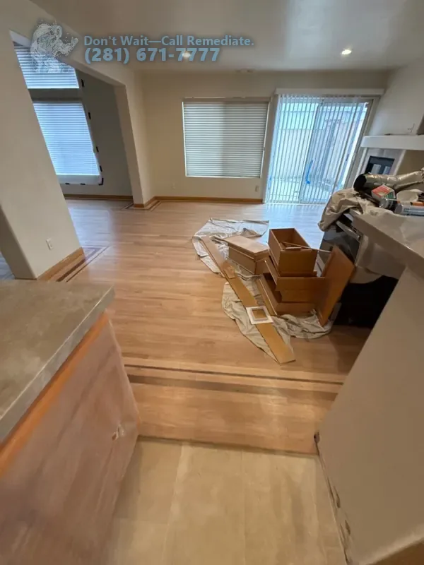New hardwood flooring going in across the living area, boxes of boards beside it