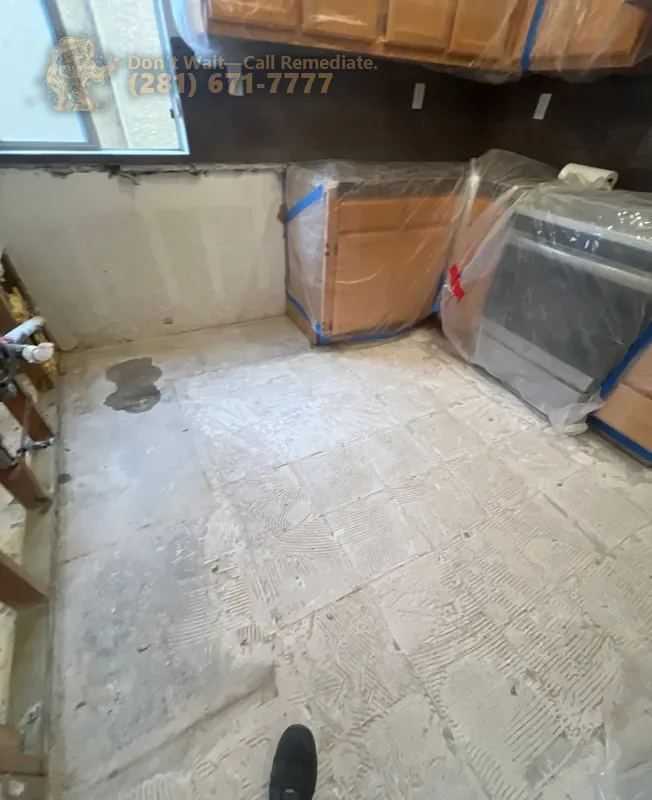 Kitchen during the work: floor and lower wall opened, appliances wrapped in plastic